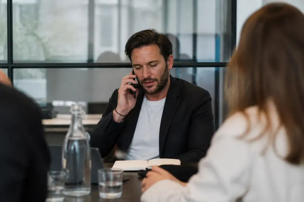 Homme au telephone et en reunion avec prospect